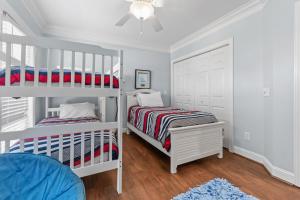 a bedroom with two bunk beds and a ceiling fan at Inn Between in Holden Beach