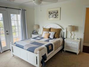 a bedroom with a bed with a blue and white comforter at Compass Rose in Holden Beach