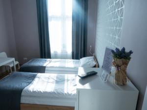 Habitación pequeña con 2 camas y mesa con escritorio. en Just4You Apartments, en Cracovia