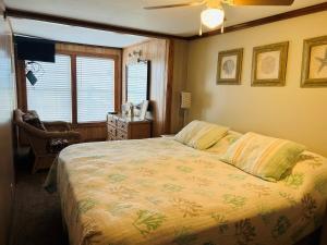 a bedroom with a bed and a chair and a window at Hidden Treasure in Holden Beach