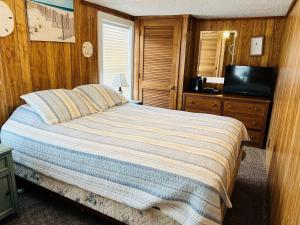 a bedroom with a bed and a television in it at Hidden Treasure in Holden Beach +21 photos