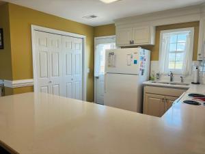 a kitchen with a white refrigerator and a counter top at Sea Biscuit in Holden Beach