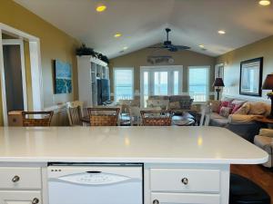 a kitchen and living room with a white counter top at Sea Biscuit in Holden Beach