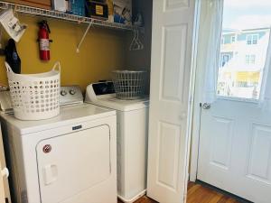 a laundry room with a washing machine and a washer at Sea Biscuit in Holden Beach
