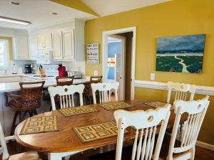 a kitchen with a wooden table and white chairs at Sea Biscuit in Holden Beach +61 photos