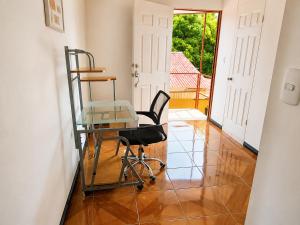 a glass table and a chair in a room at Alojamiento Vistas Chirripo espacioso con Parqueo in San Isidro de El General