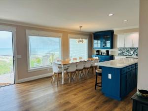 a kitchen with blue cabinets and a table and chairs at Nauti Time home in Holden Beach