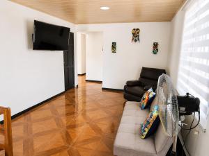 a living room with a couch and a flat screen tv at Alojamiento Vistas Chirripo espacioso con Parqueo in San Isidro de El General