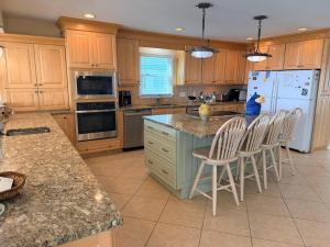 a kitchen with wooden cabinets and a white refrigerator at Majak Moments in Holden Beach