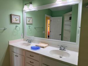 a bathroom with two sinks and a large mirror at Majak Moments in Holden Beach +111 photos