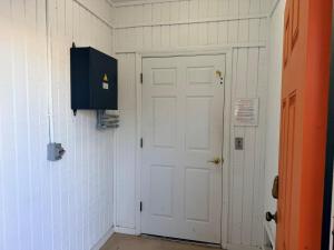 a hallway with a white door and a blue cabinet at Majak Moments in Holden Beach