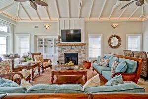 a living room with couches and a fireplace at Cinnamon Sands home in Holden Beach