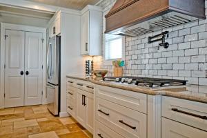 a kitchen with white cabinets and a stove at Cinnamon Sands home in Holden Beach