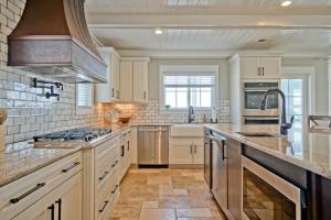 a kitchen with white cabinets and a stove top oven at Cinnamon Sands home in Holden Beach +82 photos