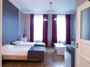 una camera con due letti, un tavolo e finestre di Just4You Apartments a Cracovia