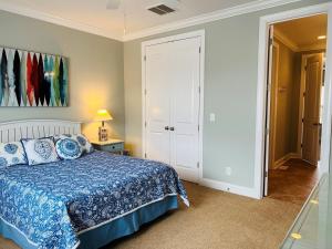 a bedroom with a bed with a blue comforter at 287 OBW home in Holden Beach