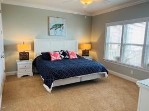a bedroom with a bed with two night stands and two lamps at 287 OBW home in Holden Beach +63 photos