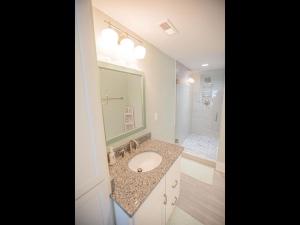a bathroom with a sink and a large mirror at The Sandbox home in Holden Beach