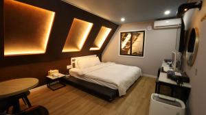 a small bedroom with a bed and a table at 수원행궁 넘버25 in Suwon