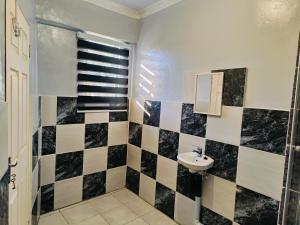 a bathroom with a black and white checkered wall at Ave Maria Camping site in Welkom