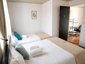 two beds in a room with white walls at Alojamiento Vistas Chirripo espacioso con Parqueo in San Isidro de El General +25 photos