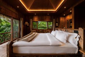 a bedroom with a large white bed in a room at Pa Sak Tong in Chiang Rai +27 photos