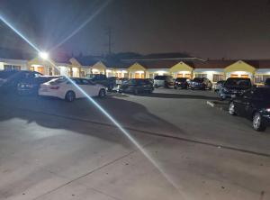 a group of cars parked in a parking lot at night at Sunrise Inn in South Gate