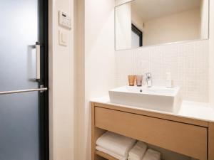 a bathroom with a sink and a mirror at NAGI Hiroshima Hotel and Lounge in Hiroshima +19 photos