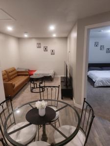 a living room with tables and chairs and a bed at Cozy Private Suite with Parking near restaurants in Regina