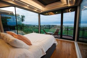 a bedroom with a bed and large glass windows at Lua Mazamitla in San Luis Soyatlán