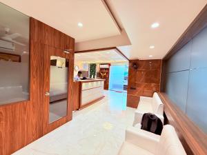 a living room with a white couch and a counter at Hotel Shree Krishna Paradise Dombivali in Dombivli