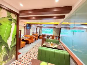 a restaurant with green chairs and tables in a room at Hotel Shree Krishna Paradise Dombivali in Dombivli