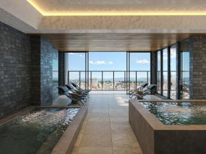 a room with a swimming pool with a view of the city at FAV LUX Asahikawa in Asahikawa