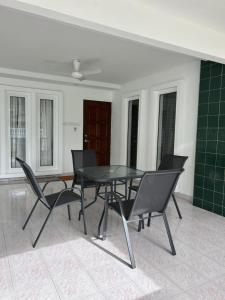 a dining room with a black table and chairs at Haus176 in Bentong