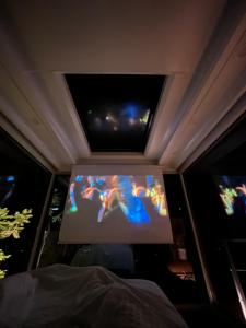 a large screen tv in a room with two windows at Lua Mazamitla in San Luis Soyatlán