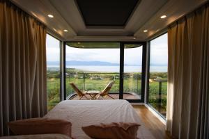 a bedroom with a bed and a large window at Lua Mazamitla in San Luis Soyatlán +6 photos