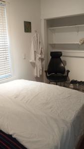a bedroom with a bed and a robe hanging on a wall at Tania's guest rooms in Calgary