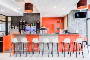 a bar in a restaurant with white stools at Hotel ParkSaône in Lyon