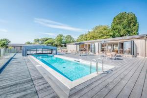 a house with a swimming pool on a wooden deck at Lodge 15 at Landscove Holiday Park in Brixham