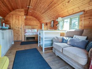 a living room with a couch and a kitchen at Gayton Stables in Wirral