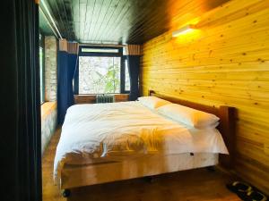 a bedroom with a bed in a wooden wall at Phủ Homestay Sapa in Sapa