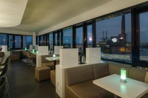 a restaurant with tables and chairs and a view of the city at INNSiDE by Meliá Wolfsburg in Wolfsburg