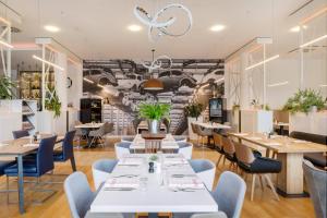 a restaurant with white tables and blue chairs at INNSiDE by Meliá Wolfsburg in Wolfsburg