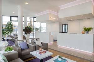 a lobby of a building with couches and tables at INNSiDE by Meliá Wolfsburg in Wolfsburg +37 photos