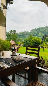 a table and chairs with a view of a field at Royal Eco Lodge in Kandy