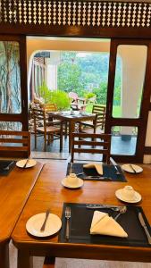 a wooden table with plates and utensils on it at Royal Eco Lodge in Kandy +20 photos