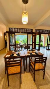 a dining room with a wooden table and chairs at Royal Eco Lodge in Kandy