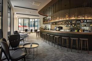 a restaurant with a bar with stools and tables at Meliá Luxembourg in Luxembourg
