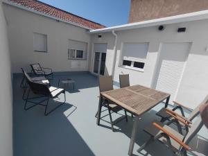 a patio with a wooden table and chairs on it at Corvera Guss in Corvera