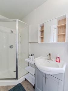 a white bathroom with a sink and a shower at Luvienna Stays in Winnipeg